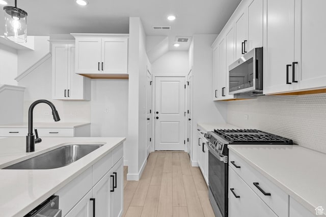 2869 S Ritter Row W Unit 54, West Valley City, UT 84128 - kitchen with white cabinets, appliances with stainless steel finishes, light countertops, pendant lighting, and a sink