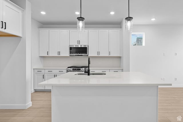 2869 S Ritter Row W Unit 54, West Valley City, UT 84128 - kitchen featuring pendant lighting, light countertops, appliances with stainless steel finishes, white cabinetry, and a sink