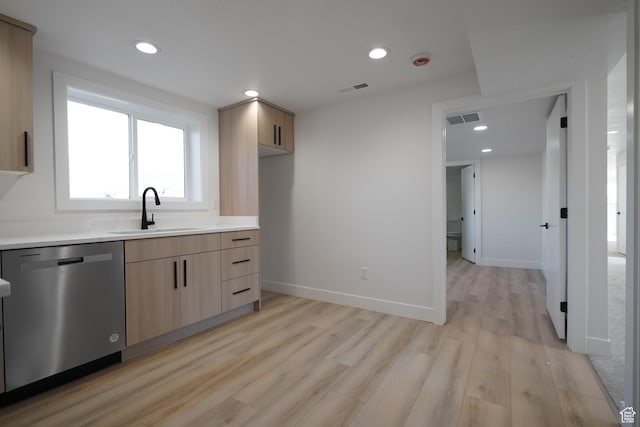 kitchen with light brown cabinetry, sink, stainless steel dishwasher, and light hardwood / wood-style floors