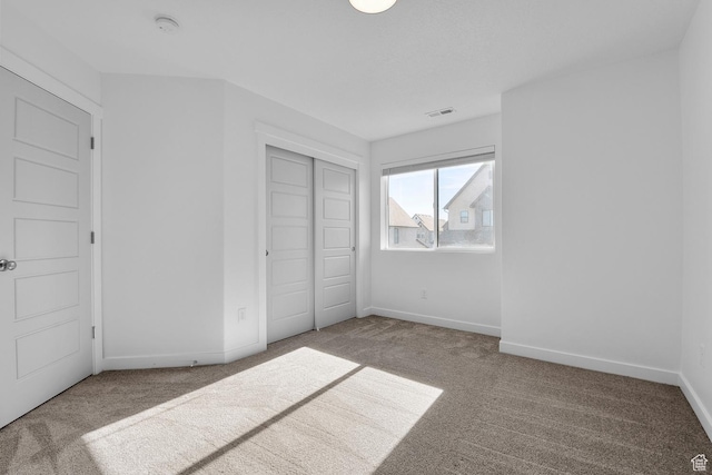 unfurnished bedroom featuring carpet and a closet