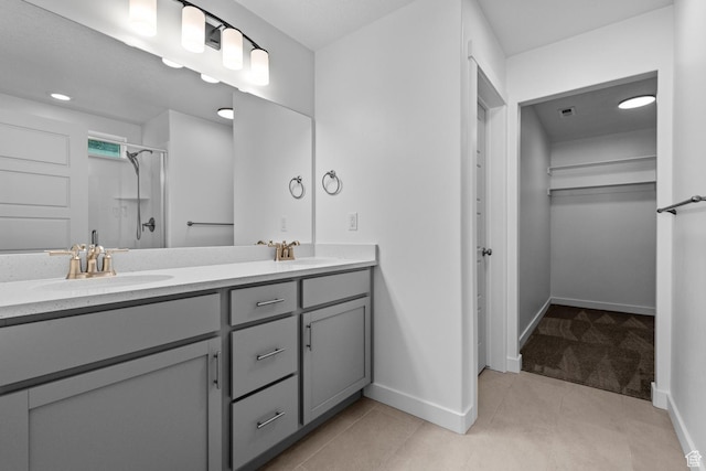 bathroom featuring walk in shower, tile patterned floors, and vanity