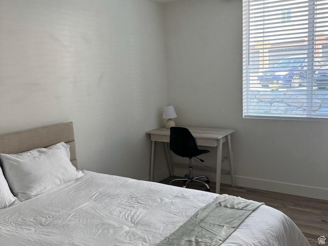 bedroom featuring baseboards and wood finished floors
