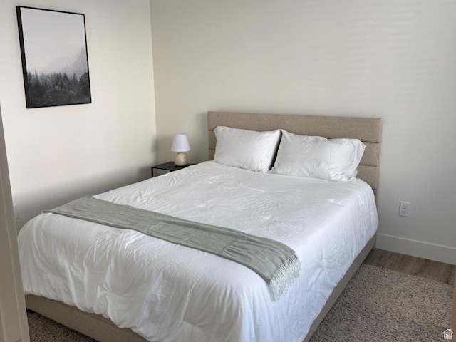 bedroom featuring baseboards and wood finished floors