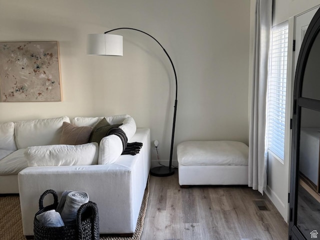 living room with visible vents, baseboards, and wood finished floors