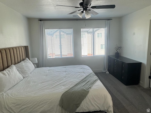 carpeted bedroom featuring a ceiling fan and a textured ceiling