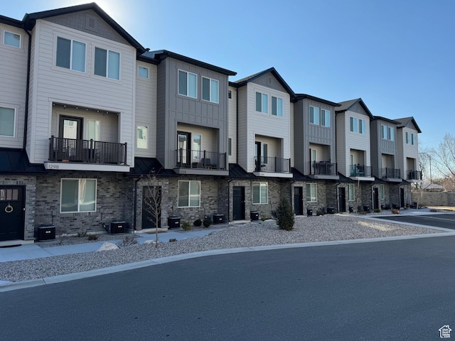 townhome / multi-family property with board and batten siding and central AC
