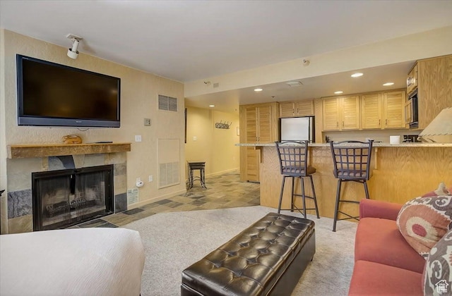 living area featuring baseboards, a fireplace, visible vents, and recessed lighting