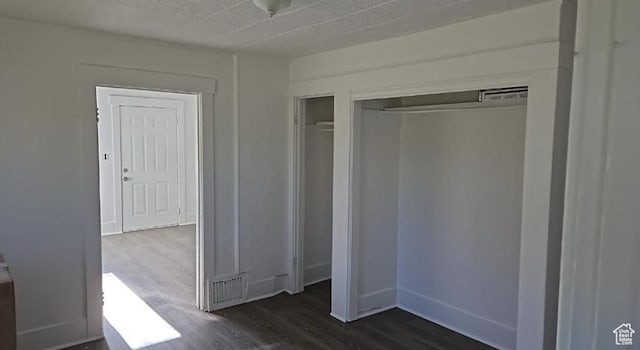 unfurnished bedroom featuring dark hardwood / wood-style flooring and a closet
