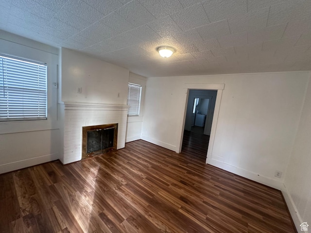 unfurnished living room featuring dark hardwood / wood-style floors and a fireplace