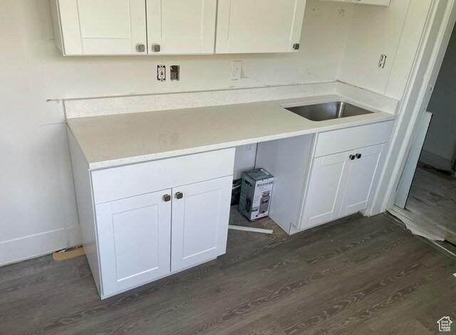 clothes washing area with dark hardwood / wood-style floors and sink