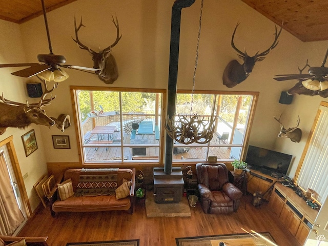 living room featuring hardwood / wood-style flooring, ceiling fan, a healthy amount of sunlight, and a wood stove