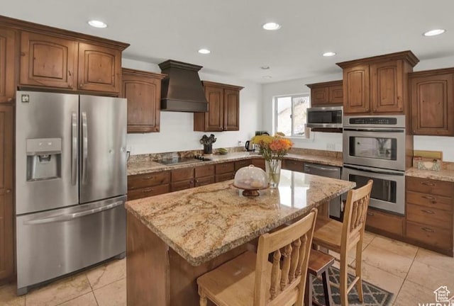 14548 S Rose Ave, Herriman, UT 84096 - kitchen featuring premium range hood, a kitchen island, a breakfast bar, light tile patterned floors, and stainless steel appliances