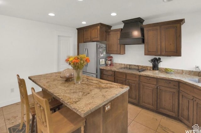 14548 S Rose Ave, Herriman, UT 84096 - kitchen with stainless steel fridge, a kitchen bar, a center island, black electric stovetop, and custom range hood