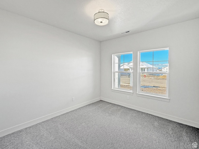 carpeted spare room with baseboards and visible vents