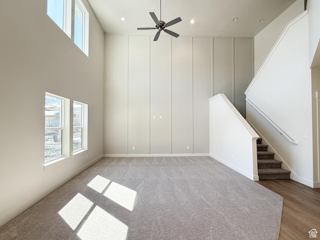 unfurnished living room featuring ceiling fan, recessed lighting, wood finished floors, and stairs