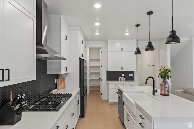 6850 Mountain Maple Dr Unit 14, Park City, UT 84098 - kitchen featuring white cabinetry, an island with sink, pendant lighting, light stone countertops, and wall chimney range hood