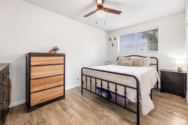 bedroom featuring a textured ceiling, ceiling fan, and light wood-type flooring