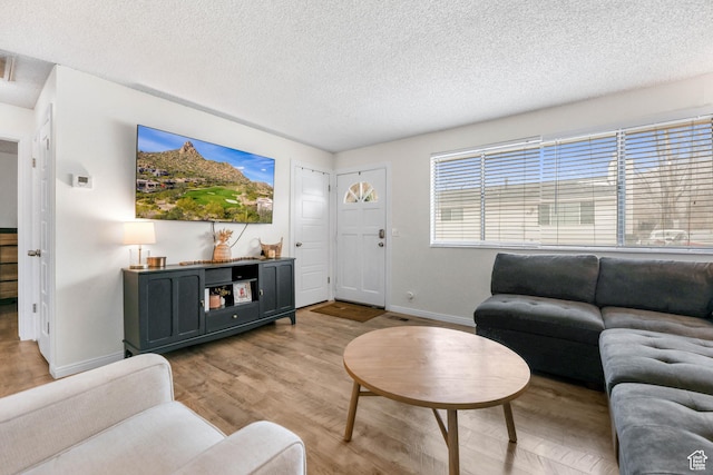 living room with light hardwood / wood-style floors and a textured ceiling