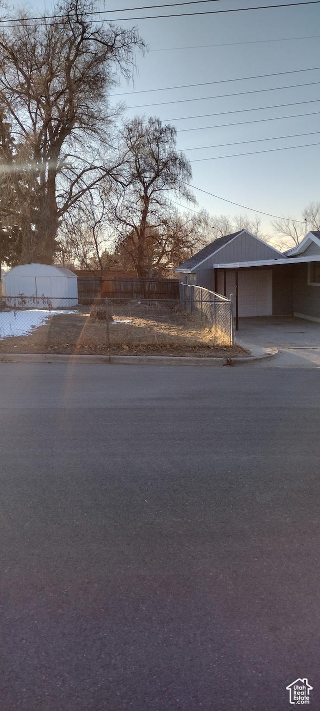 view of front of property featuring driveway and fence