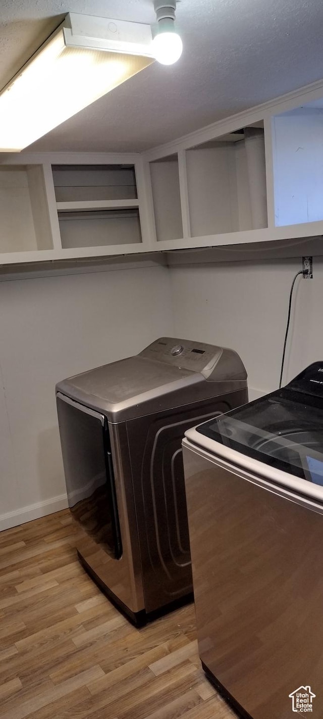 washroom featuring light wood finished floors, independent washer and dryer, and laundry area