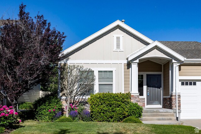 7104 S Cadens Cv, Cottonwood Heights, UT 84121 - view of front of property featuring an attached garage, board and batten siding, stone siding, and a shingled roof