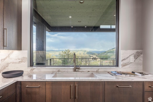 1817 W Skyridge Dr, Heber City, UT 84032 - kitchen with a sink, dark brown cabinetry, backsplash, and light stone countertops