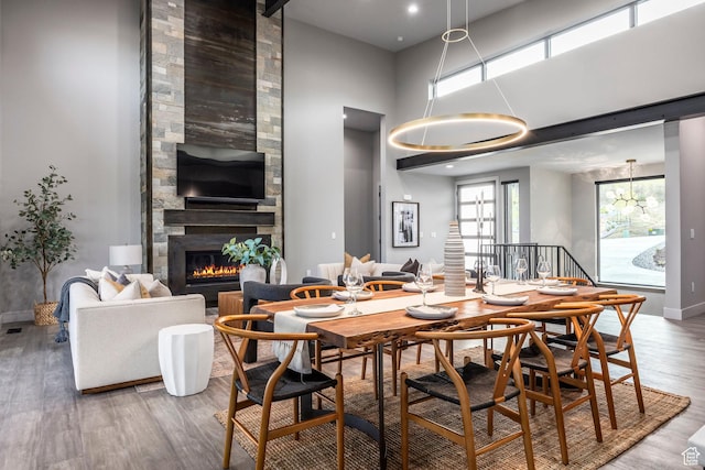 1817 W Skyridge Dr, Heber City, UT 84032 - dining room featuring wood finished floors, a large fireplace, a chandelier, baseboards, and a high ceiling