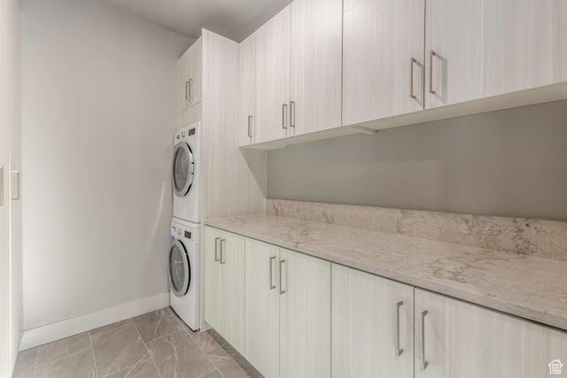 laundry room featuring cabinets and stacked washer and dryer