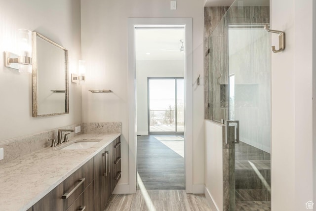 bathroom with vanity, hardwood / wood-style flooring, and a shower with door