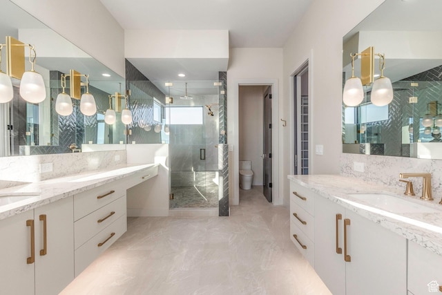 bathroom featuring a shower with door, vanity, backsplash, and toilet