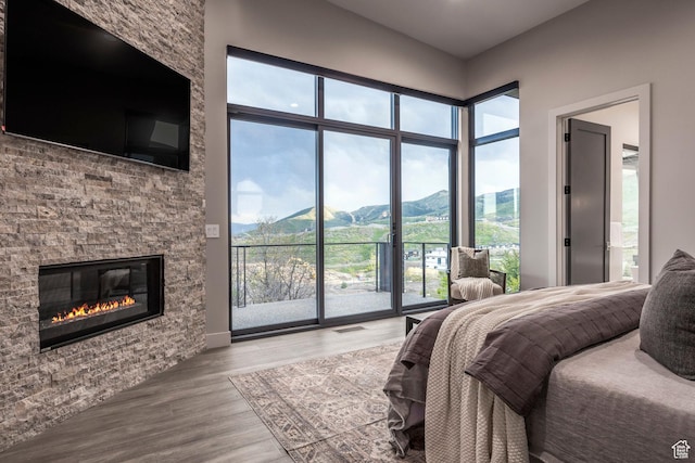 1817 W Skyridge Dr, Heber City, UT 84032 - bedroom with access to outside, wood finished floors, multiple windows, and a fireplace