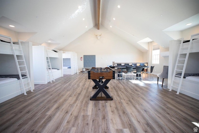 interior space with high vaulted ceiling, beam ceiling, hardwood / wood-style floors, and a wall unit AC