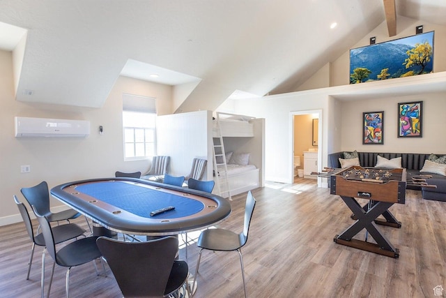 playroom with vaulted ceiling with beams, a wall mounted air conditioner, and light hardwood / wood-style flooring