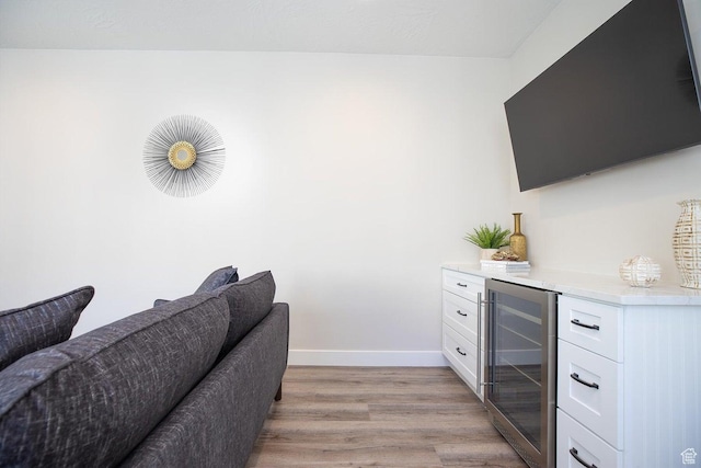interior space featuring indoor bar, beverage cooler, and light hardwood / wood-style flooring