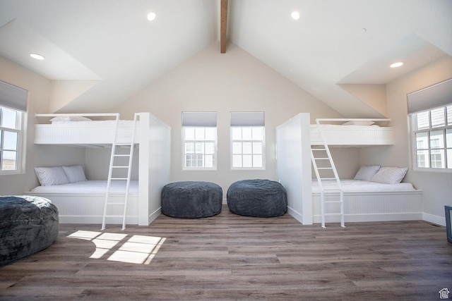 bedroom with hardwood / wood-style flooring, high vaulted ceiling, and beam ceiling
