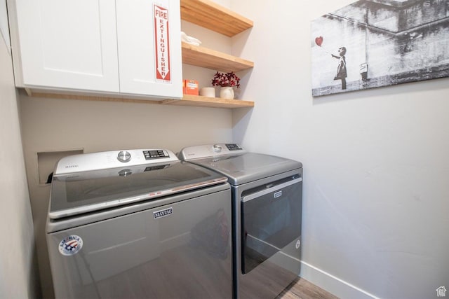 laundry room with washing machine and dryer and cabinets