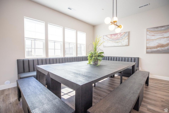 dining space with hardwood / wood-style floors, a notable chandelier, and breakfast area