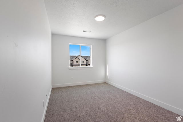 empty room featuring carpet floors and a textured ceiling