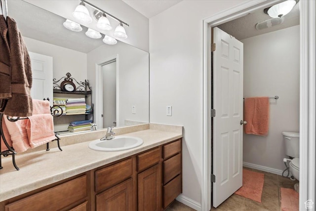 bathroom with vanity, baseboards, and toilet