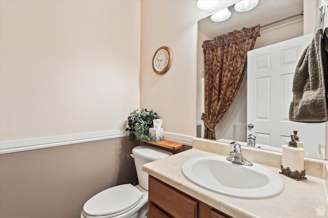 bathroom with toilet, curtained shower, and vanity