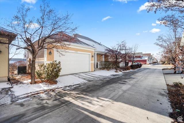 view of front of house featuring a garage, driveway, and central AC