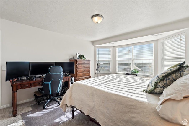 bedroom with visible vents, baseboards, carpet floors, and a textured ceiling