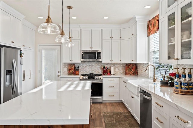 kitchen with dark wood finished floors, white cabinetry, a kitchen island, appliances with stainless steel finishes, and a sink