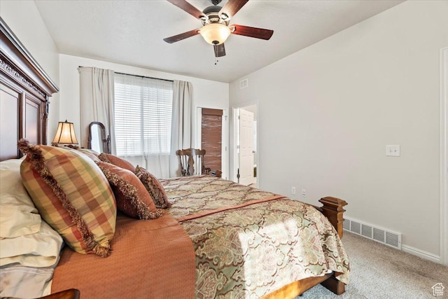 carpeted bedroom with visible vents, baseboards, and a ceiling fan
