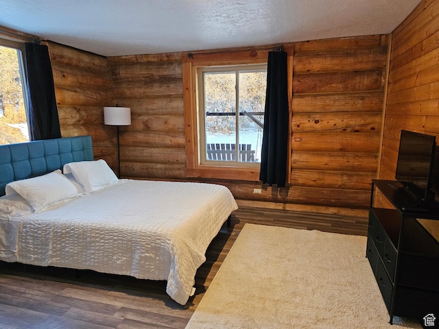 11905 E 24560 N, Fairview, UT 84629 - bedroom with log walls, dark hardwood / wood-style flooring, and a textured ceiling