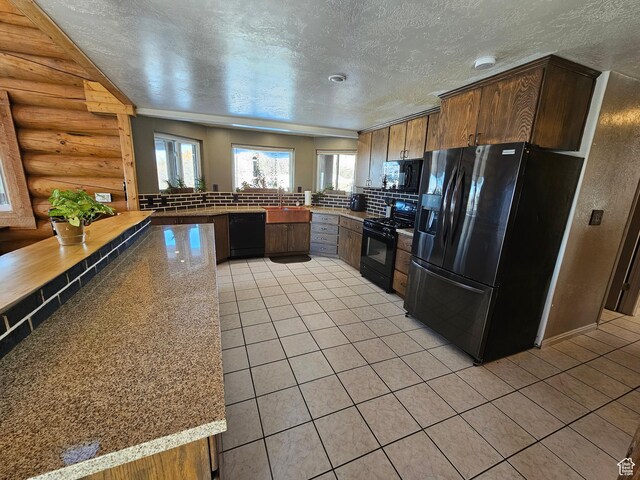 11905 E 24560 N, Fairview, UT 84629 - kitchen with rustic walls, sink, kitchen peninsula, light stone countertops, and black appliances