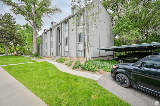 view of side of home featuring a carport and a yard