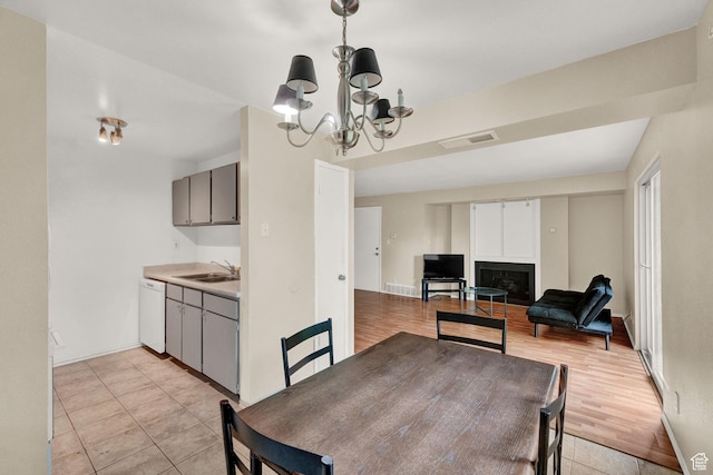 dining area featuring an inviting chandelier, light tile patterned floors, and sink
