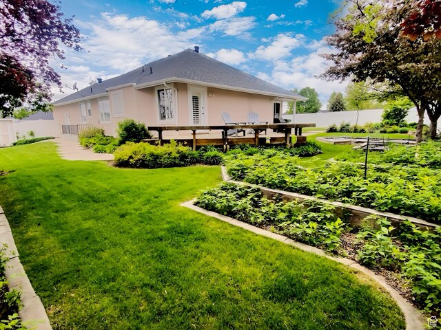 818 Summit Dr, Smithfield, UT 84335 - back of house with a vegetable garden, stucco siding, and a deck