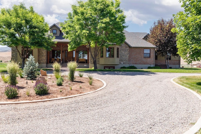 655 W 85 S, Glenwood, UT 84730 - view of property hidden behind natural elements with a porch, brick siding, curved driveway, and a shingled roof